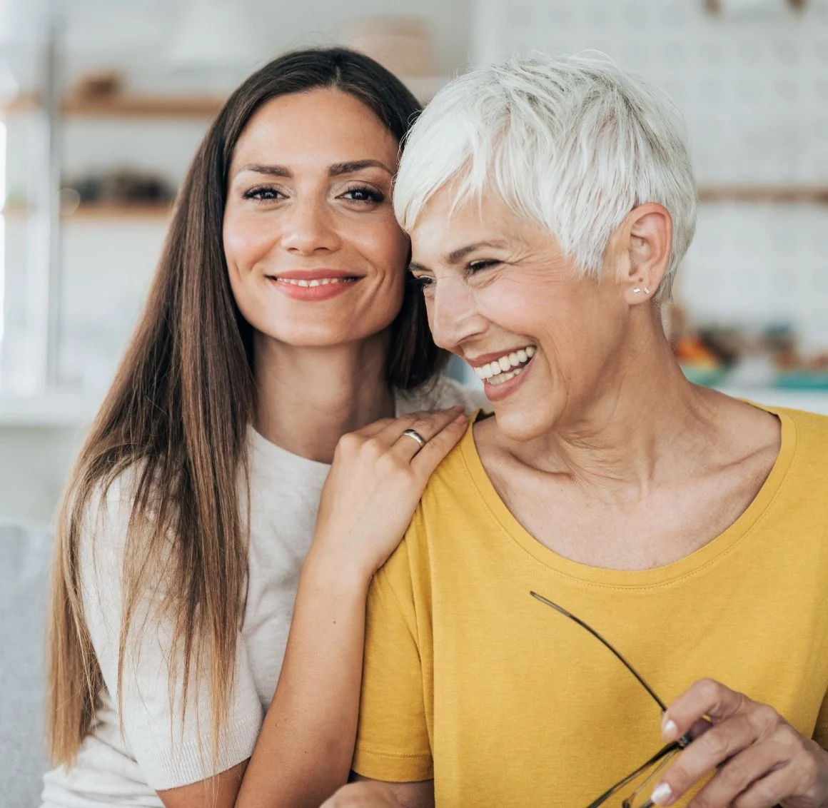 daughter-and-senior-mother-smiling-close-up-indoors