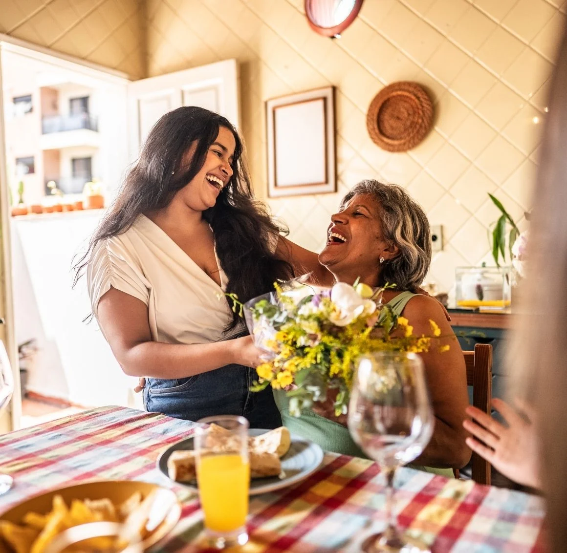 granddaughter-giving-flowers-to-senior-woman-at-dinner caregiver offering companionship to a senior