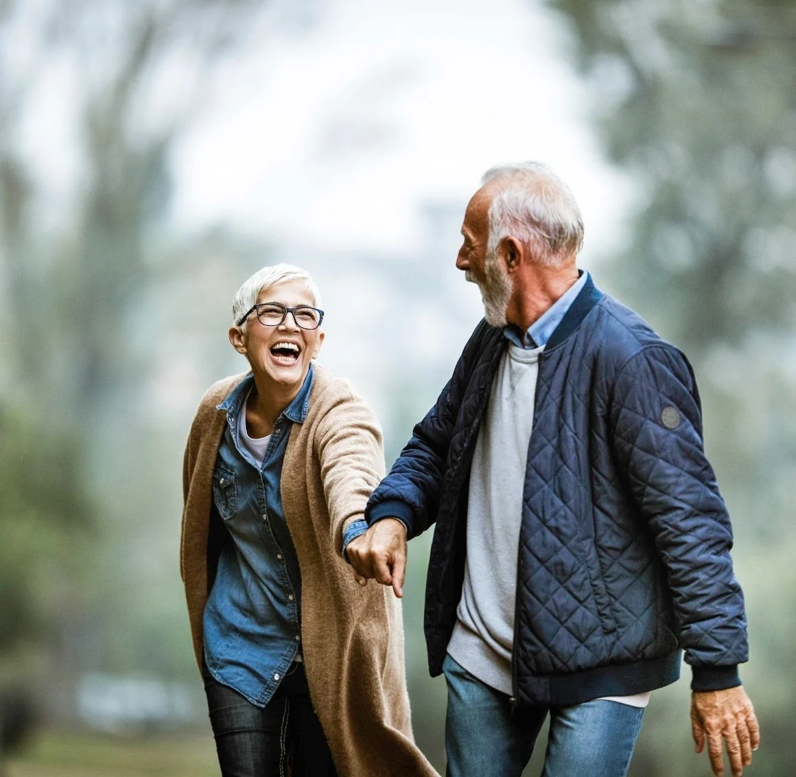 senior-couple-holding-hands-laughing-outdoors