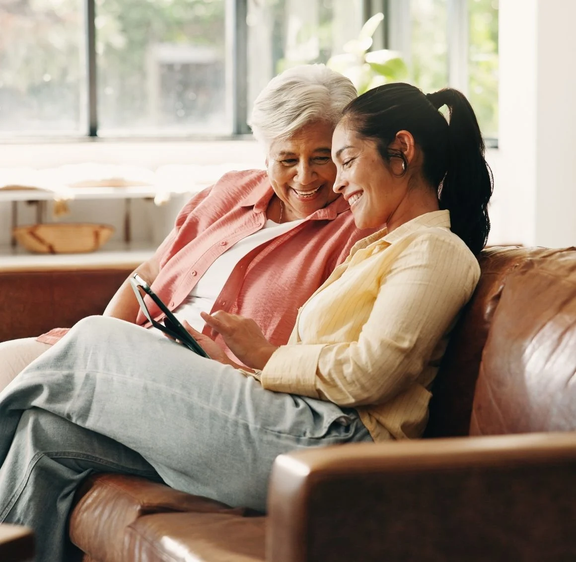 senior-woman-and-daughter-looking-at-tablet-on-couch