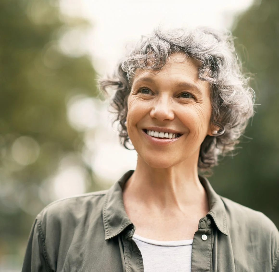 smiling-woman-with-curly-gray-hair-outdoors-portrait we provide senior home care in Utica